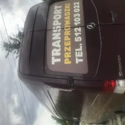 Tył bordowego busa Mercedes Sprinter z naklejonym napisem 'TRANSPORT PRZEPROWADZKI TEL. 512 103 022' na tylnych drzwiach, widziany z boku.