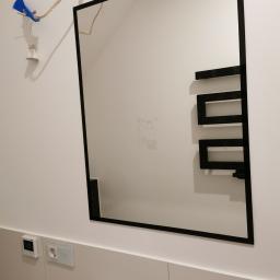 Lustro z czarną malowana ramka w szkle przyklejane bezpośrednio do ściany. 
