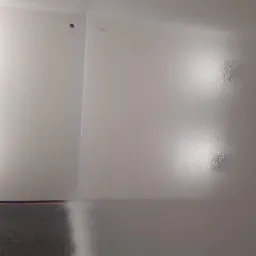 Świeżo pomalowana na biało ściana w rogu pokoju, z widoczną folią ochronną przy podłodze i delikatnym połyskiem mokrej farby.