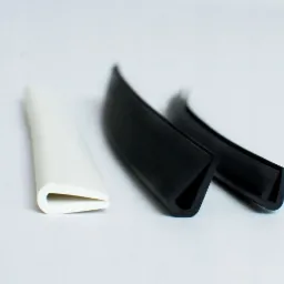 Profil uszczelniający w kształcie litery U: biały i dwa czarne, leżące na białym tle, prezentujące przekrój poprzeczny.