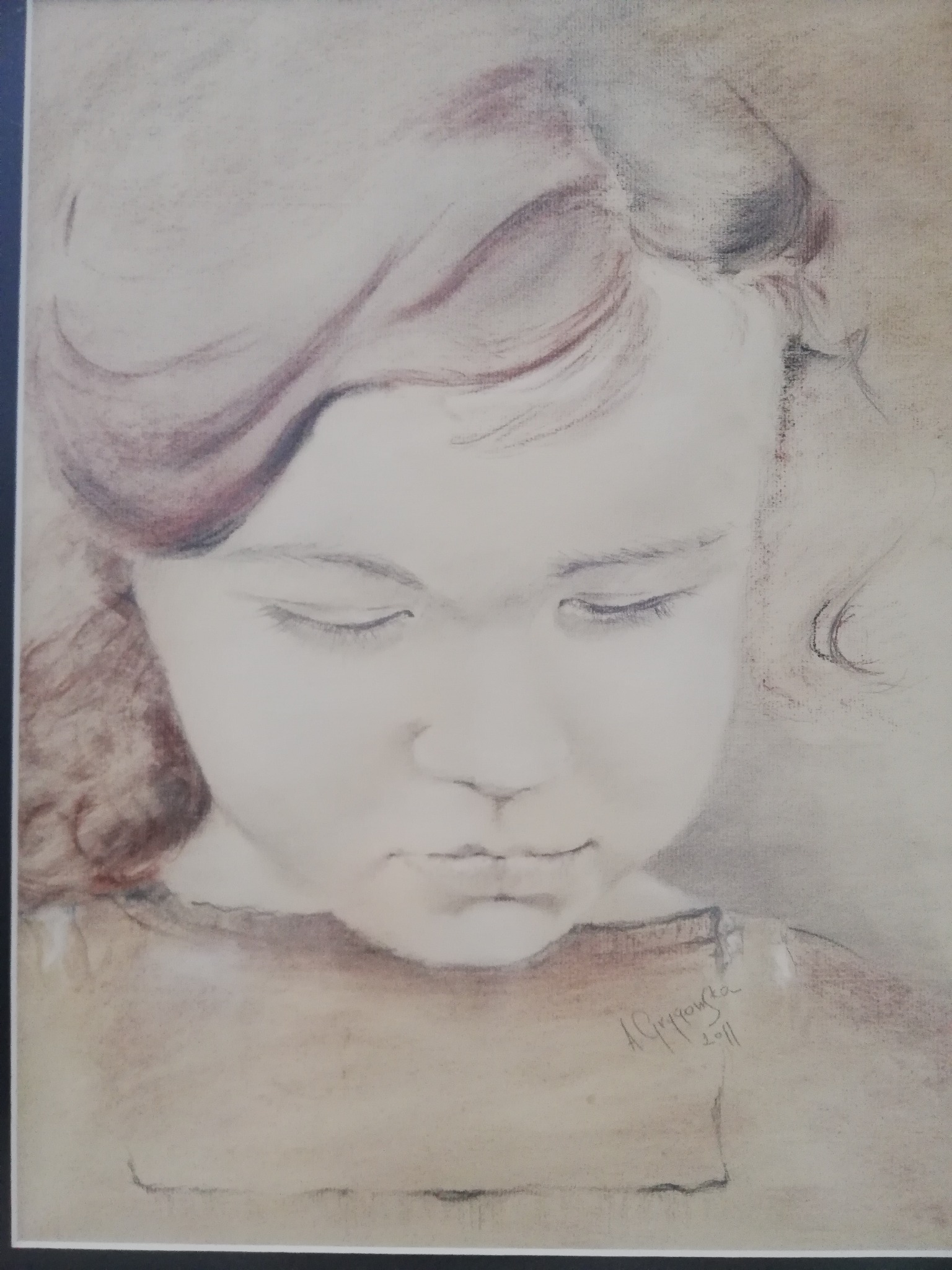 Portret dziewczynki z zamkniętymi oczami, wykonany pastelami w brązowo-szarej tonacji, podpisany w prawym dolnym rogu.