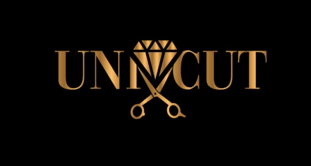 Złote logo 'UNCUT' z diamentem i nożyczkami na czarnym tle.