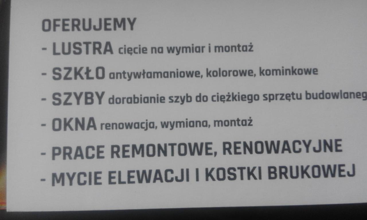 Tablica informacyjna z ofertą usług: lustra na wymiar, szkło antywłamaniowe i kominkowe, szyby do sprzętu budowlanego, okna, prace remontowe i mycie elewacji.