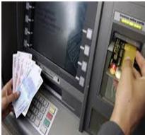 Osoba wkłada kartę do bankomatu, trzymając w drugiej ręce plik banknotów euro.