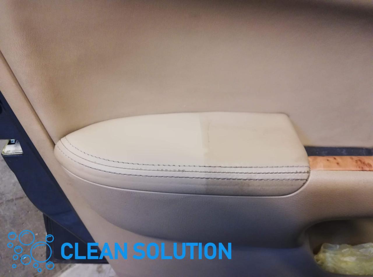 Fragment tapicerki samochodowej w kolorze beżowym, z widocznym efektem czyszczenia - różnica między obszarem wyczyszczonym a zabrudzonym.