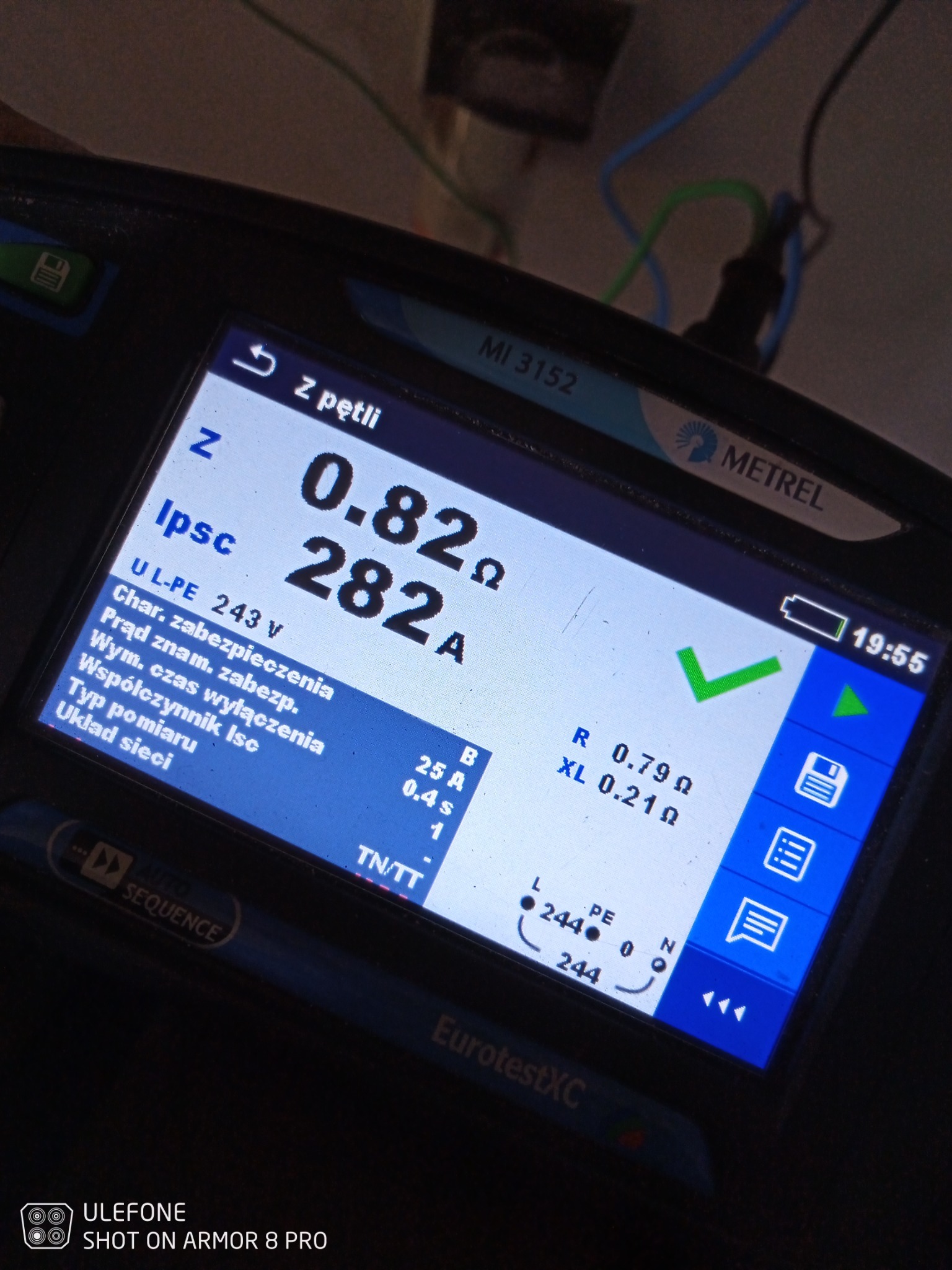 Miernik Metrel EurotestXC wyświetlający wyniki pomiarów impedancji pętli zwarcia, wskazujący wartości rezystancji i prądu zwarciowego, z widocznymi przewodami pomiarowymi w tle.