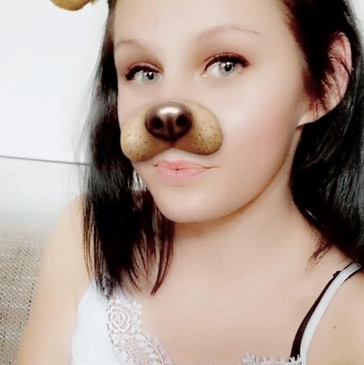 Portret kobiety z nałożonym filtrem psa, widoczny element koronki na białym topie.