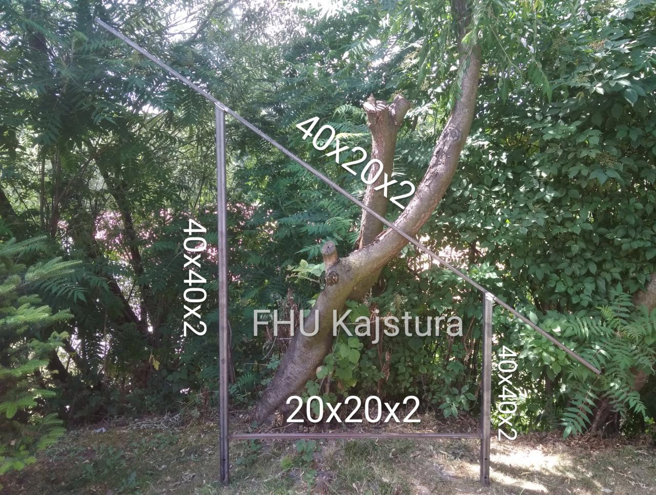 Spawana konstrukcja metalowa, rury o przekroju kwadratowym, wkomponowana w naturalne otoczenie drzew i zieleni, z widocznymi wymiarami rur naniesionymi na zdjęcie.