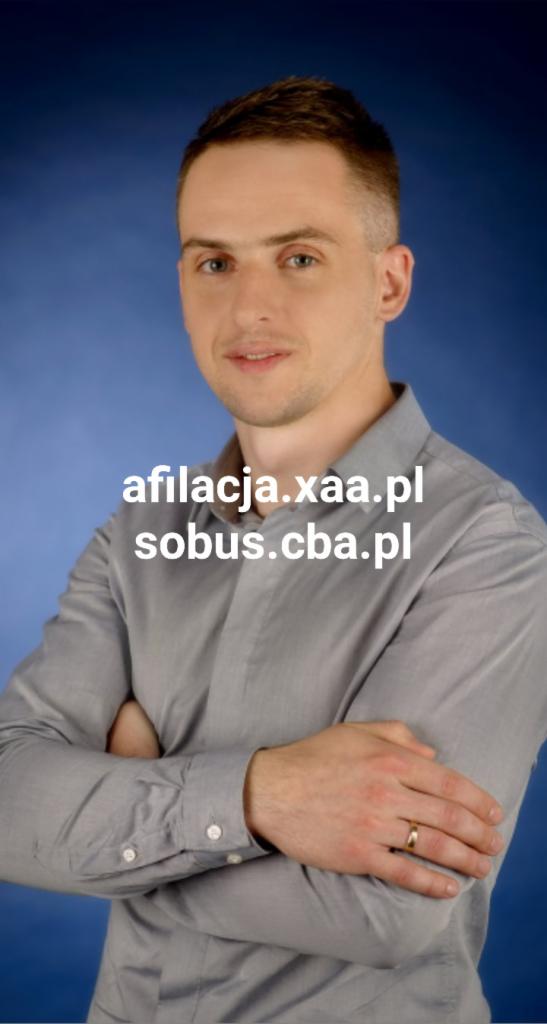 Portret mężczyzny w szarej koszuli z podwiniętymi rękawami, skrzyżowanymi ramionami i obrączką na palcu, na niebieskim tle. Na koszuli widoczne adresy stron internetowych.