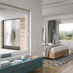 Nowoczesne, przesuwne okno w białej ramie, widok na garderobę z drewnianymi panelami, w tle sypialnia z łóżkiem i oknem na ogród.