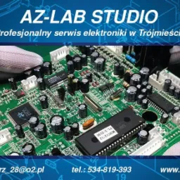 Płyta główna z elektroniką w rękawicach ochronnych, logo firmy AZ-LAB STUDIO w tle. Widoczne kondensatory, układy scalone i inne elementy elektroniczne.