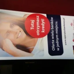 Roll-up reklamowy Fines operator bankowy z uśmiechniętą kobietą i hasłem 'Tutaj otrzymasz kredyt!' oraz logotypami banków.