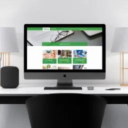 Ekran komputera iMac wyświetlający stronę internetową Medica Centrum dla gabinetów specjalistycznych, na biurku z dwiema lampami ze złotymi podstawami i głośnikiem Apple HomePod.