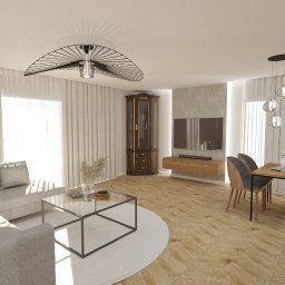 BOHO STUDIO - Salon z parkietem w jodełkę, szarą sofą, szklanym stolikiem kawowym na okrągłym dywanie, antyczną witryną i telewizorem na ścianie. Uwagę przyciąga designerski żyrandol.