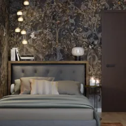 Sypialnia z ceglaną ścianą, łóżkiem z szarą tapicerką i zagłówkiem, tapetą w motywy roślinne i lampą wiszącą z kulistymi kloszami. Na stoliku nocnym świece.