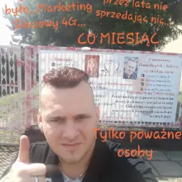 Mężczyzna z podniesionym kciukiem na tle baneru reklamowego firmy 7PLAY oferującej partnerski pakiet medyczny i marketing sieciowy 4G, z napisem 'Tylko poważne osoby' i hasztagami #LUPEK #LIVE #TEAM.