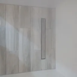 Wykończona ściana w łazience z szarymi, drewnopodobnymi płytkami ceramicznymi i odpływem liniowym w podłodze, widok z niskiego kąta.