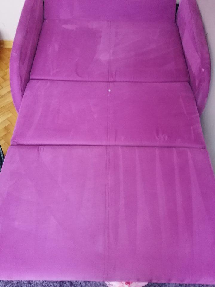 Fioletowa rozkładana kanapa po czyszczeniu, widoczne jaśniejsze ślady po ekstrakcji brudu na powierzchni tapicerki.