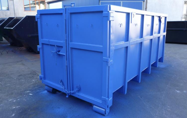 Niebieski, metalowy kontener na gruz z zamkniętymi drzwiami, widoczne łańcuchy zabezpieczające i rolki do przesuwania, ustawiony na betonowym podłożu.