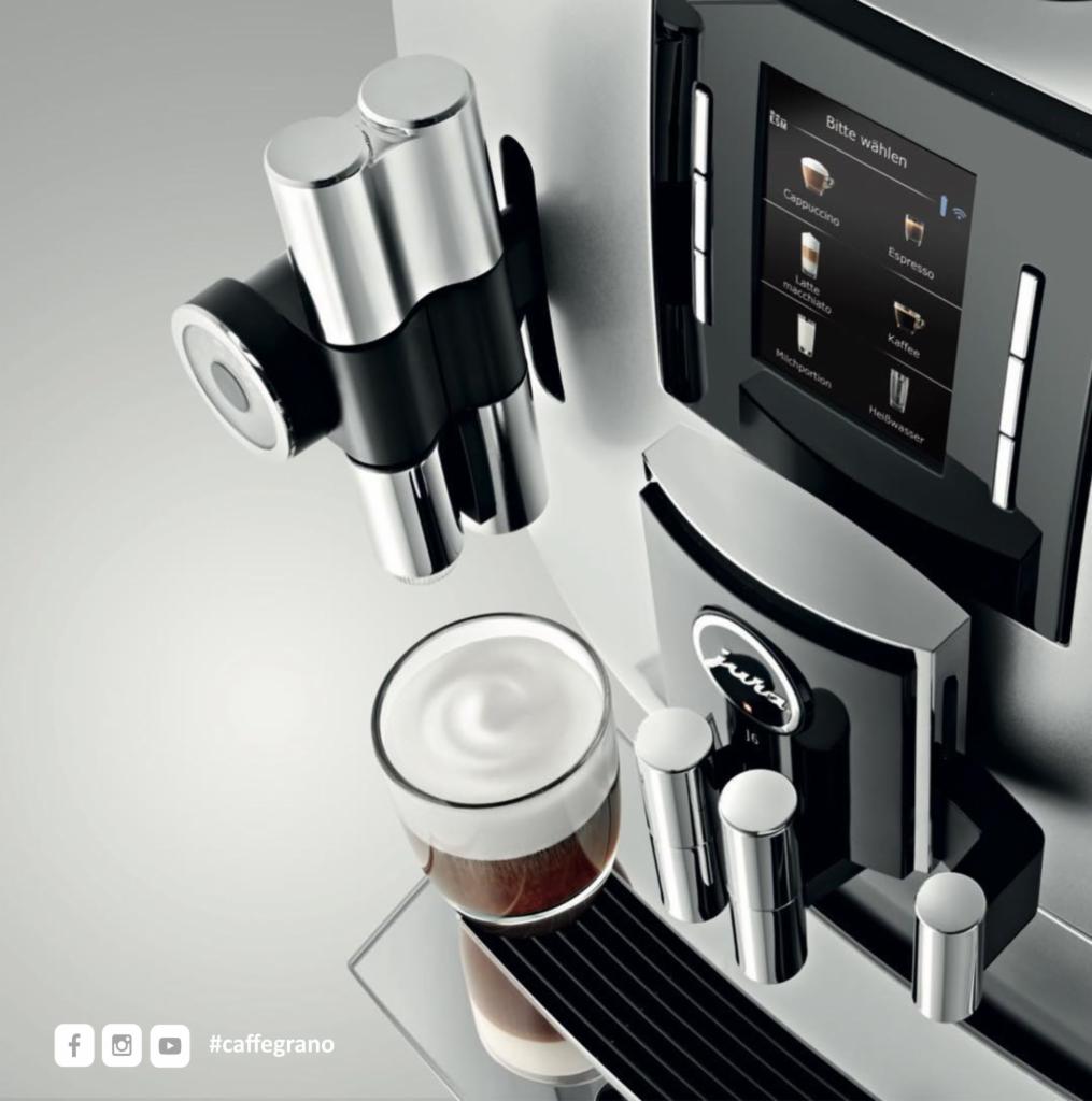 Automatyczny ekspres do kawy Jura z dotykowym wyświetlaczem, przygotowujący latte macchiato, widok z góry.