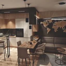 Wnętrze mieszkania z otwartą kuchnią, drewnianymi akcentami i mapą świata na ścianie, oświetlone nowoczesnymi lampami wiszącymi.