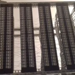 Rozdzielnica elektryczna z zamontowanymi zabezpieczeniami nadprądowymi, widok z dołu, z widocznymi przewodami.