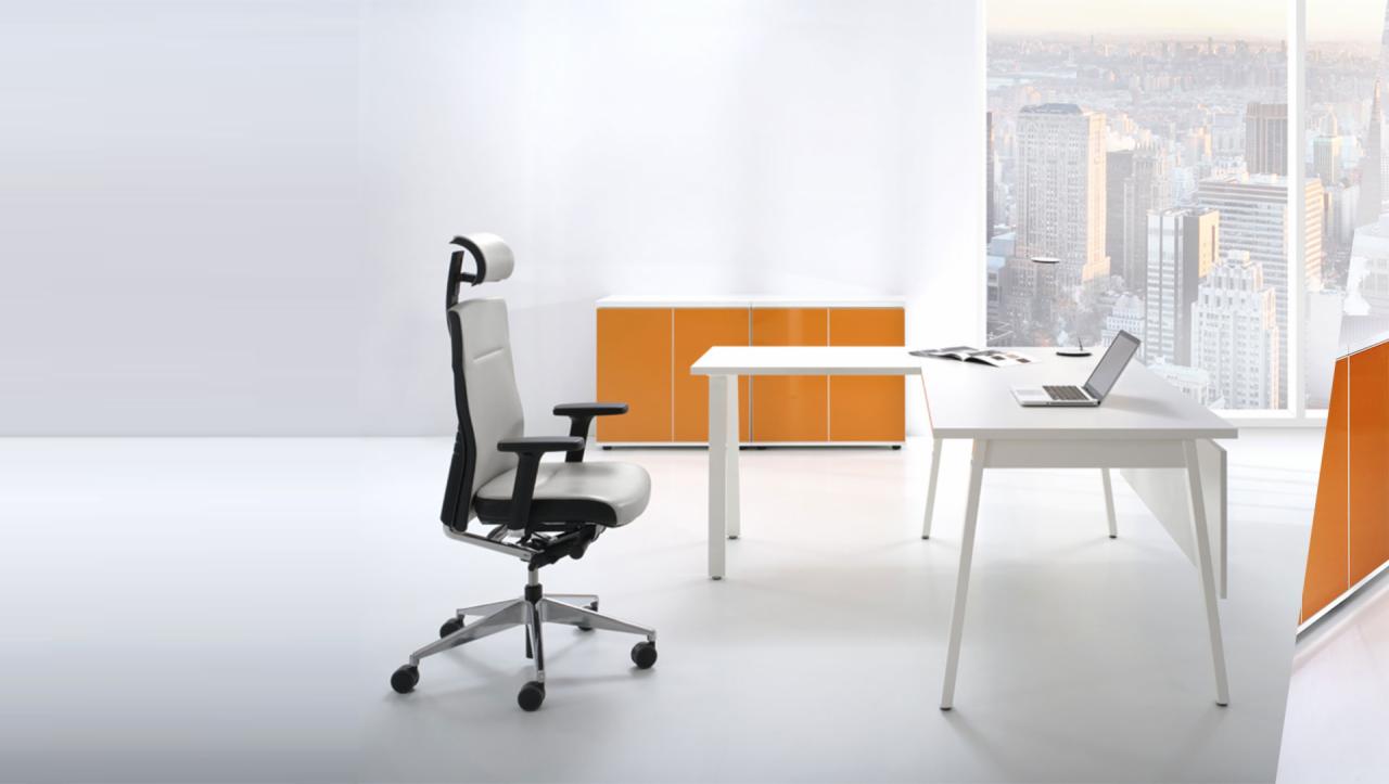 Ergonomiczne krzesło biurowe z regulowanym zagłówkiem, białe biurka z laptopem, pomarańczowa szafka i widok na panoramę miasta za oknem.
