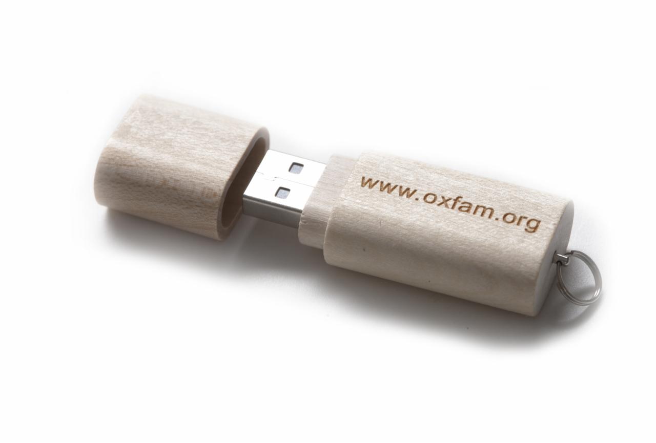 Drewniany pendrive z wygrawerowanym adresem www.oxfam.org, z otwartą zatyczką i metalowym kółkiem do zawieszki.