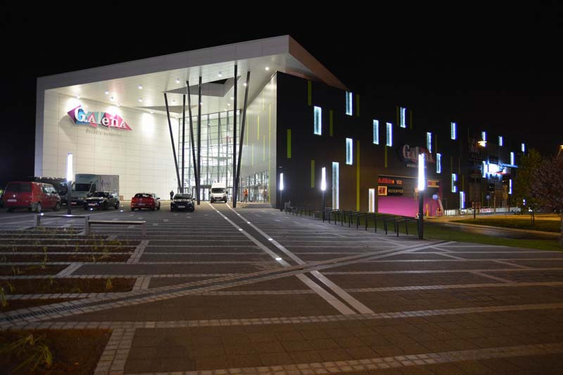 Nocne ujęcie Galerii Handlowej Galena w Jaworznie, prezentujące elewację z płyt warstwowych i oświetleniem.