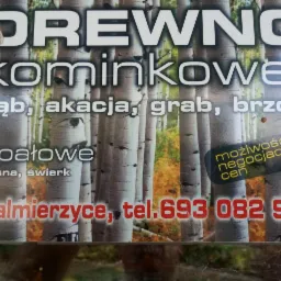 Ogłoszenie drukowane z tekstem 'Drewno kominkowe' i numerem telefonu, na tle brzozowego lasu, informujące o sprzedaży drewna opałowego dębu, akacji, grabu, brzozy, sosny i świerku z możliwością...