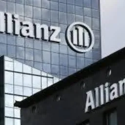 Budynki biurowe z dużym logo Allianz na fasadzie, wykonane w pochmurny dzień.