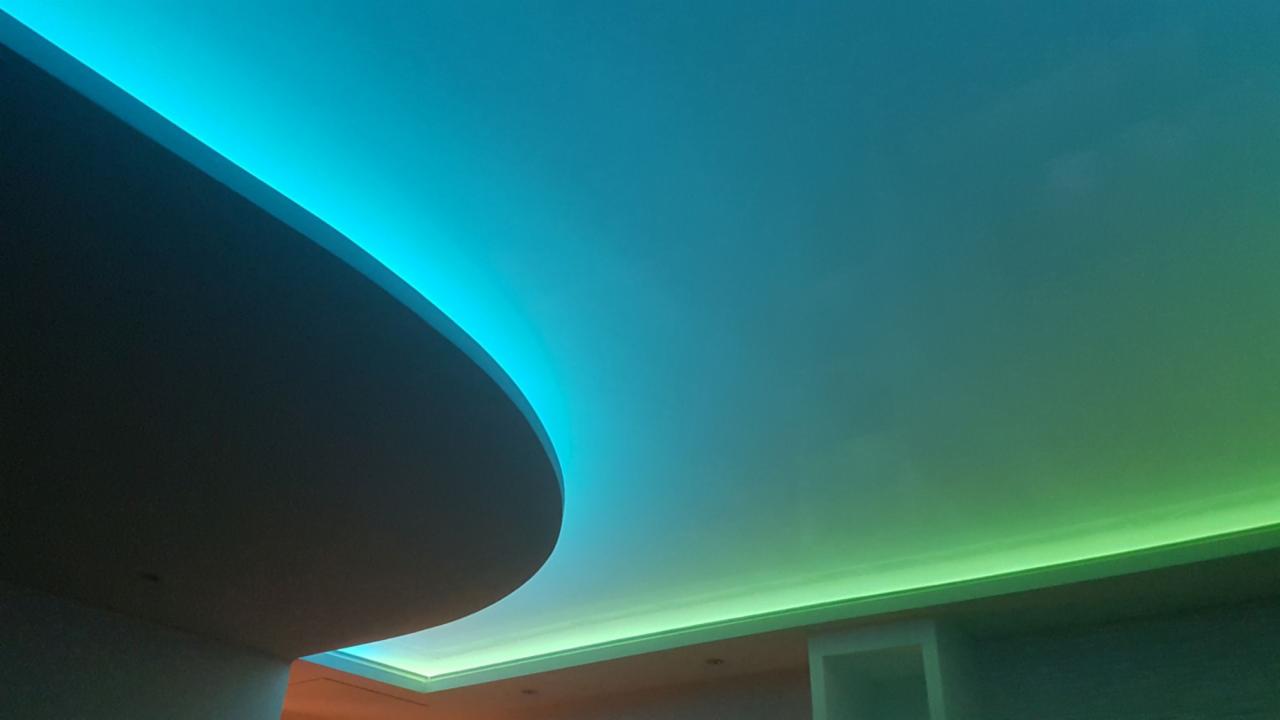 Podwieszany sufit z oświetleniem LED w kolorach niebieskim i zielonym, tworzący nowoczesny efekt wizualny.