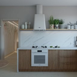 LEAN Pracownia wnętrz - Wnętrze kuchni w neutralnej kolorystyce z drewnianymi szafkami, marmurowym blatem i białymi sprzętami AGD, ozdobione ziołami w doniczkach i dekoracyjnymi słoikami na półce.