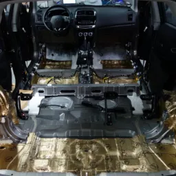 Wnętrze samochodu Mitsubishi ASX w trakcie wygłuszania, widoczne maty wygłuszające STP Gold na podłodze i w nadkolach, zdemontowane fotele i elementy tapicerki.