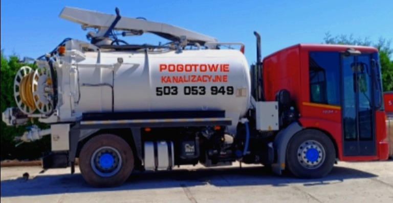 Pojazd asenizacyjny z napisem 'POGOTOWIE KANALIZACYJNE' i numerem telefonu, wyposażony w bęben z wężem i wysięgnik, zaparkowany na betonowym placu w słoneczny dzień.