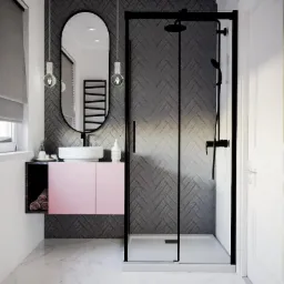 Nowoczesna łazienka z kabiną prysznicową typu walk-in, umywalką nablatową na różowej szafce, owalnym lustrem i szarą ścianą wyłożoną płytkami w jodełkę; widoczne marmurowe płytki podłogowe.