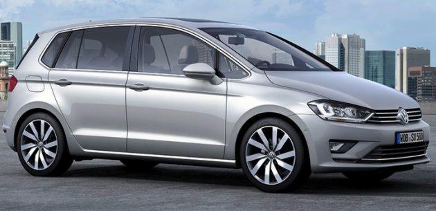 Srebrny samochód typu hatchback na tle miejskiego krajobrazu z nowoczesnymi wieżowcami.