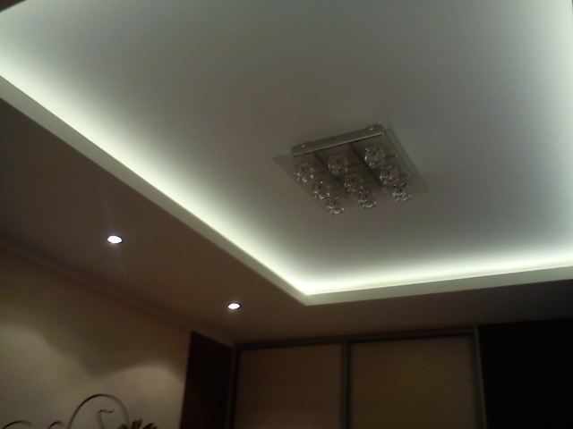 Podwieszany sufit z oświetleniem LED i kwadratową lampą sufitową z kryształkami, widok z dołu.