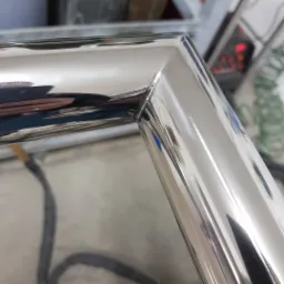 Szczegół połączenia kątowego polerowanej, metalowej konstrukcji, prawdopodobnie fragmentu balustrady.