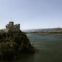 Panorama jeziora Czorsztyńskiego z zamkiem w Niedzicy sfotografowanym z drona w słoneczny dzień.