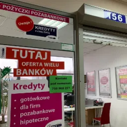 Wejście do placówki finansowej z reklamami kredytów gotówkowych, dla firm, pozabankowych i hipotecznych; widoczny numer lokalu 156 oraz informacja o ofercie wielu banków.
