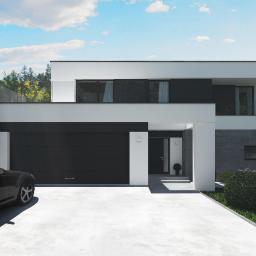 Castor Pracownia Projektowa Agata Sobkowiak - Nowoczesny dom z płaskim dachem, czarną bramą garażową i szklaną balustradą balkonu, widok z przodu z samochodem na podjeździe.