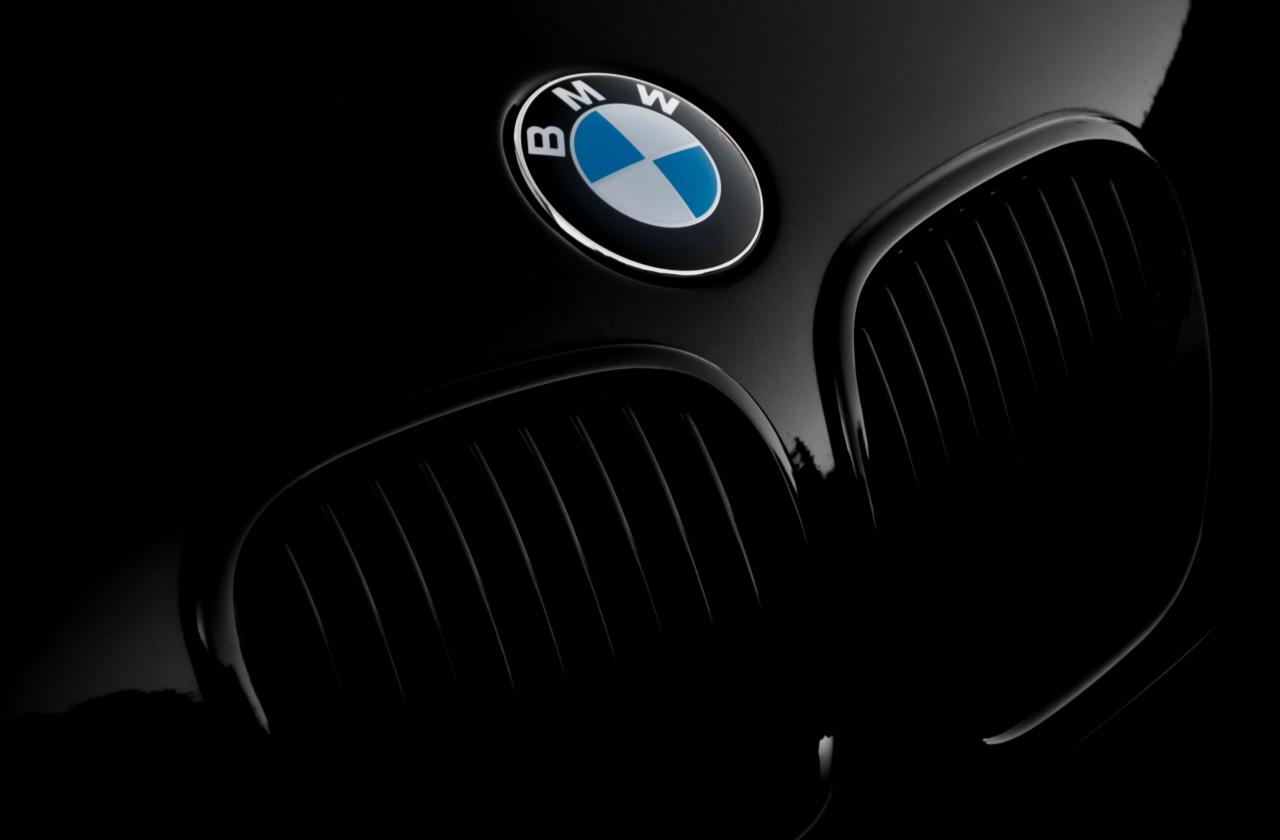Czarny grill BMW z chromowanym logo na masce, ujęcie w ciemnym otoczeniu z widocznymi detalami.