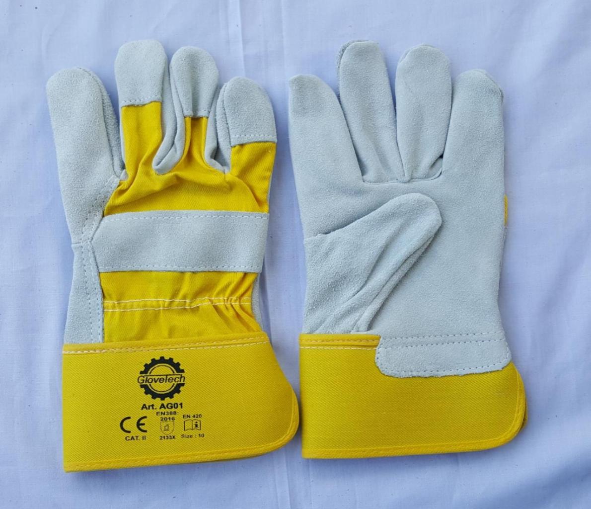 Para nowych, roboczych rękawic ochronnych z żółtym mankietem i szarą częścią dłoniową, leżących na białym tle, z widocznym logo i oznaczeniami certyfikacyjnymi.