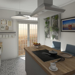 Pam W. Atelier - Jasna kuchnia z wyspą, na której znajduje się płyta indukcyjna z garnkiem, filiżanka kawy i miska owoców. Nad wyspą wisi nowoczesny okap. Na ścianie wiszą obrazy i pionowy panel z sukulentami.