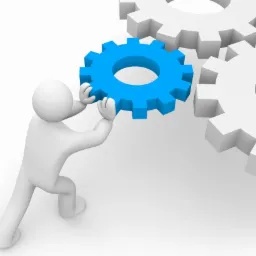 Animowana postać ustawia niebieskie koło zębate obok dwóch białych kół zębatych na białym tle, symbolizując mechanizm działania.