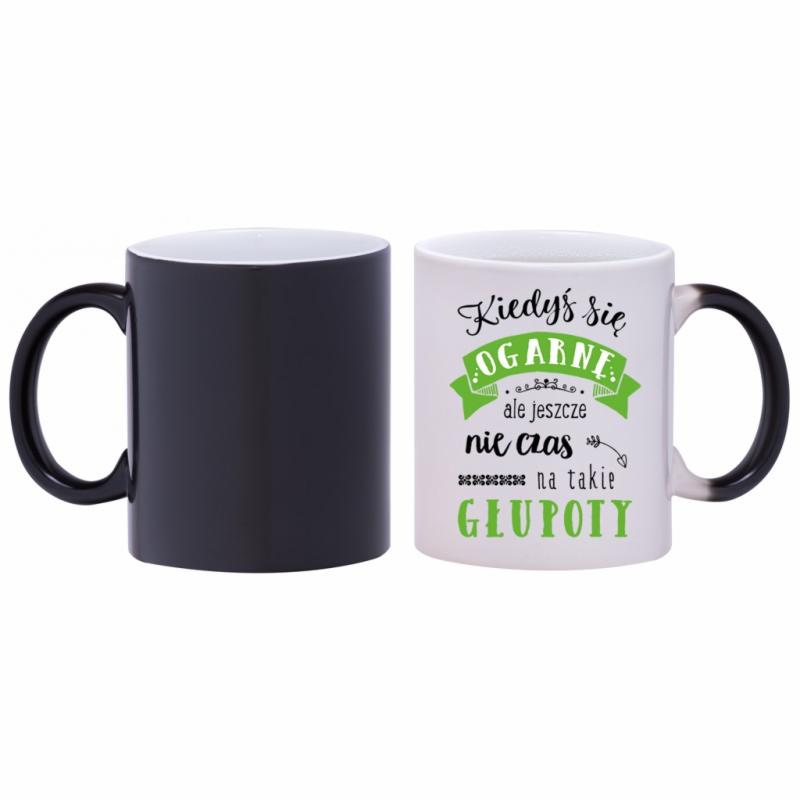 Dwa kubki ceramiczne: czarny i biały z napisem 'Kiedyś się ogarnę, ale jeszcze nie czas na takie głupoty', ustawione obok siebie na białym tle.