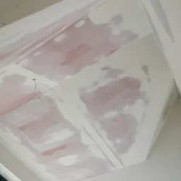 Skośny sufit z widocznymi łączeniami płyt gipsowo-kartonowych przed szpachlowaniem, wystający kabel oświetleniowy, widok z dołu na okno.