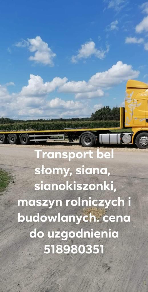 Żółta ciężarówka z niskopodwoziową naczepą, na której transportowane są bele słomy. W tle pole i błękitne niebo.