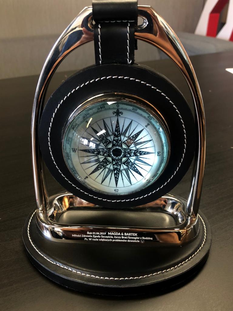 Stojący kompas w czarno-srebrnej obudowie z wygrawerowanymi życzeniami ślubnymi, dedykowany jako upominek dla Magdy i Bartka.